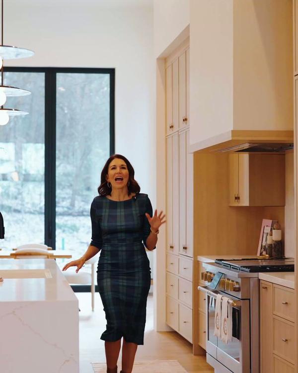 Agent standing in a bright kitchen with pale timber cabinetry.