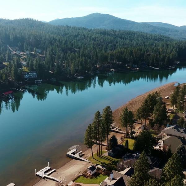 Aerial drone view of waterfront homes and shoreline.